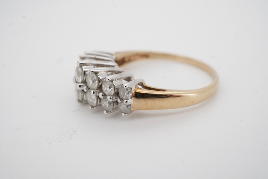 A modern 9ct gold and diamond half hoop ring, set with two graduated rows of seven diamonds, size M/N, gross weight 3.1 grams. Condition - fair to good